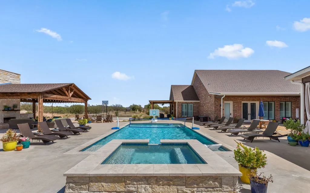 1134 Kinta Trial Home in Wichita Falls, Texas. Discover this unique 10-acre property in Clay County, featuring a stunning 6-bedroom home with 6.5 bathrooms, 6 fireplaces, a heated pool, outdoor kitchen, and even a catfish pond for fishing.