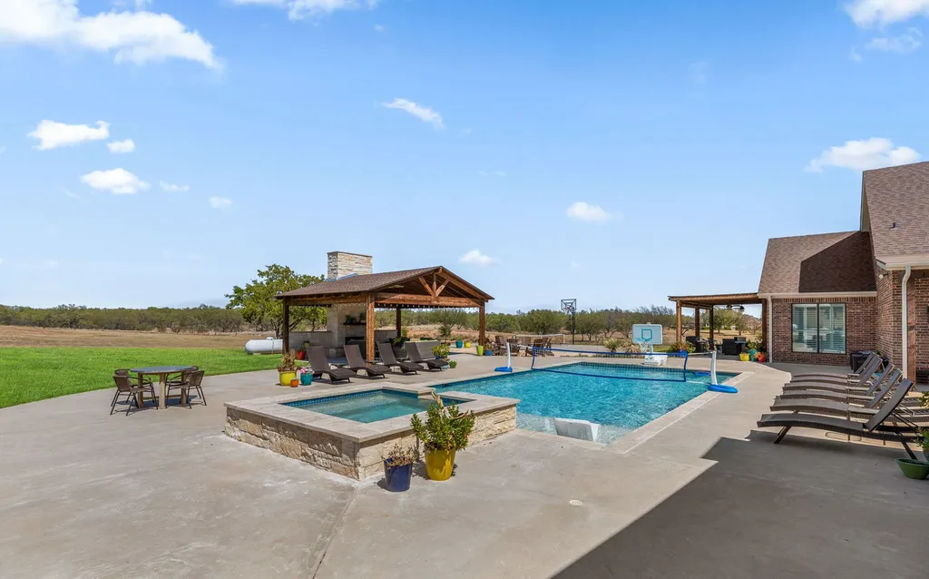 1134 Kinta Trial Home in Wichita Falls, Texas. Discover this unique 10-acre property in Clay County, featuring a stunning 6-bedroom home with 6.5 bathrooms, 6 fireplaces, a heated pool, outdoor kitchen, and even a catfish pond for fishing.