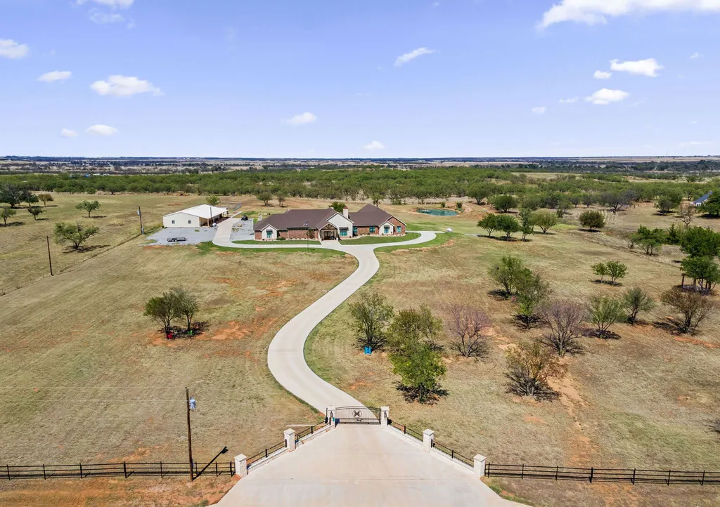 1134 Kinta Trial Home in Wichita Falls, Texas. Discover this unique 10-acre property in Clay County, featuring a stunning 6-bedroom home with 6.5 bathrooms, 6 fireplaces, a heated pool, outdoor kitchen, and even a catfish pond for fishing.