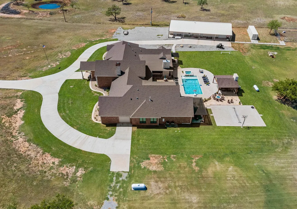 1134 Kinta Trial Home in Wichita Falls, Texas. Discover this unique 10-acre property in Clay County, featuring a stunning 6-bedroom home with 6.5 bathrooms, 6 fireplaces, a heated pool, outdoor kitchen, and even a catfish pond for fishing.