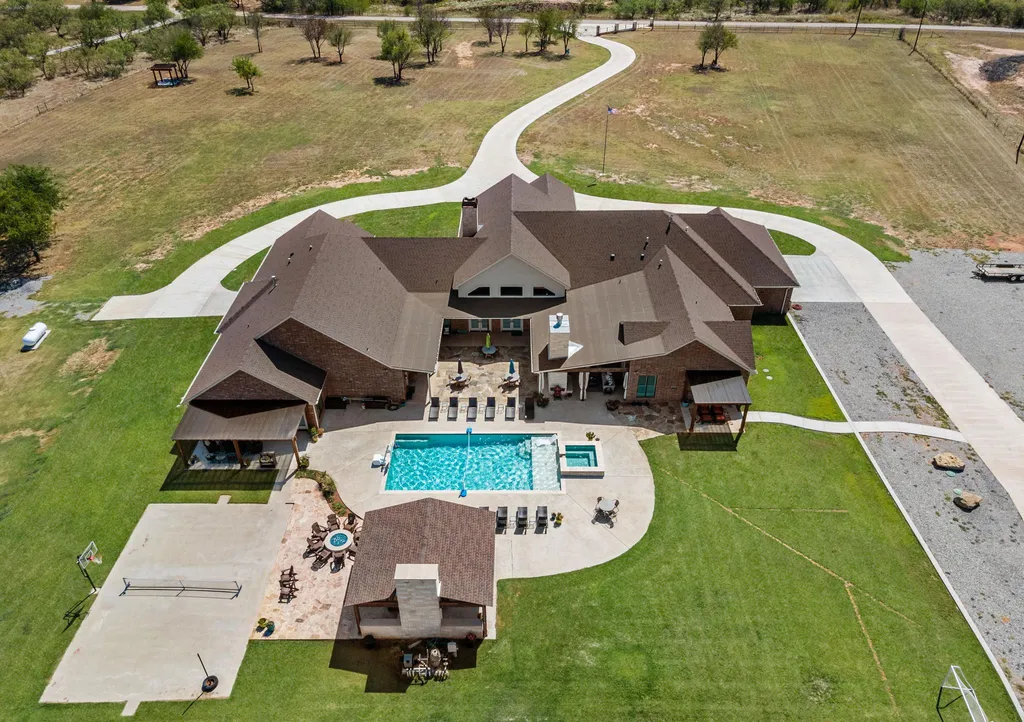 1134 Kinta Trial Home in Wichita Falls, Texas. Discover this unique 10-acre property in Clay County, featuring a stunning 6-bedroom home with 6.5 bathrooms, 6 fireplaces, a heated pool, outdoor kitchen, and even a catfish pond for fishing.