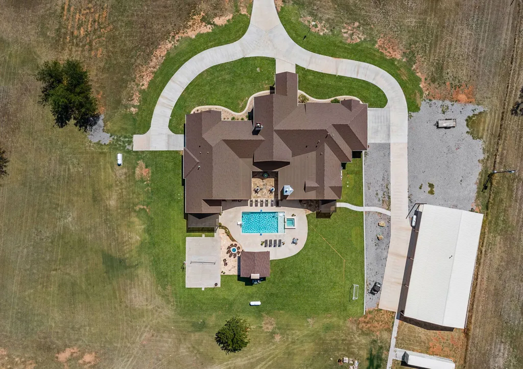 1134 Kinta Trial Home in Wichita Falls, Texas. Discover this unique 10-acre property in Clay County, featuring a stunning 6-bedroom home with 6.5 bathrooms, 6 fireplaces, a heated pool, outdoor kitchen, and even a catfish pond for fishing.