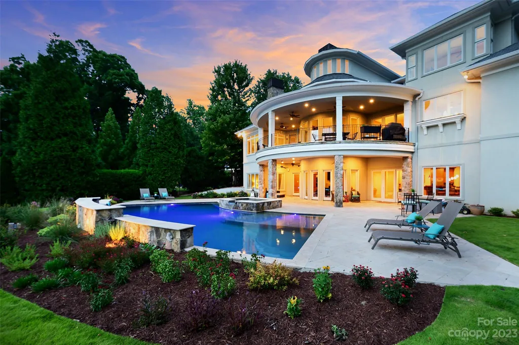 11717 Smart Lane Home in Charlotte, North Carolina. Experience the epitome of modern elegance in this gated estate with breathtaking views of the signature 13th hole from nearly every room and the stunning 48-ft pool. Designed by Christopher Phelps and crafted by Simonini, this home boasts an open floor plan, tall windows, curved walls, and a sweeping custom staircase inspired by Art Deco design.