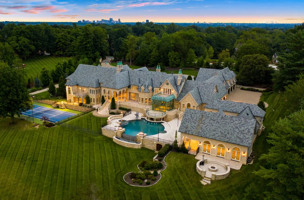 1705 North Woodlawn Avenue Home in Saint Louis, Missouri. Nestled on 7.5 acres of picturesque landscape with captivating tree-lined views, this French-inspired estate is a true masterpiece that harmonizes effortlessly with its serene surroundings. The property boasts an impressive ensemble of architectural wonders, including the main residence, a luxurious pool complex, a private lake, guest housing, and grand auto courts.