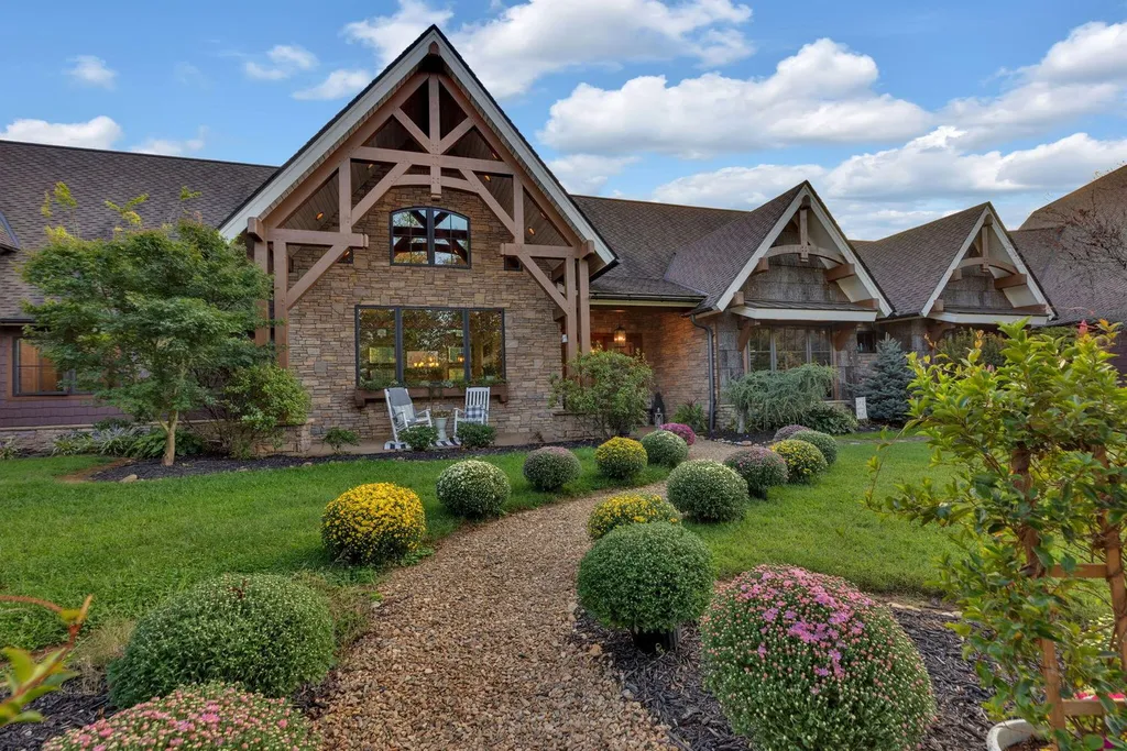 180 Riverwalk Court Home in Greeneville, Tennessee. Discover your dream oasis on this breathtaking 5-acre riverfront property! This extraordinary 7,000+ sqft home seamlessly blends transitional architecture with rustic charm, creating a captivating retreat. The striking blend of stone and poplar wood siding on the exterior exudes warmth and charm.