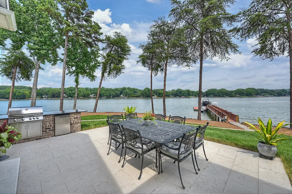211 Quaker Road Home in Mooresville, North Carolina. Experience the ultimate waterfront living on Lake Norman with this beautifully renovated home situated on a 1.25-acre cul-de-sac lot boasting 365 ft of shoreline. Enjoy breathtaking lake views from almost every room, a stunning kitchen with Wolf & SubZero appliances, private pier with boat lift and Jet Ski docks, an elevator, and so much more. 