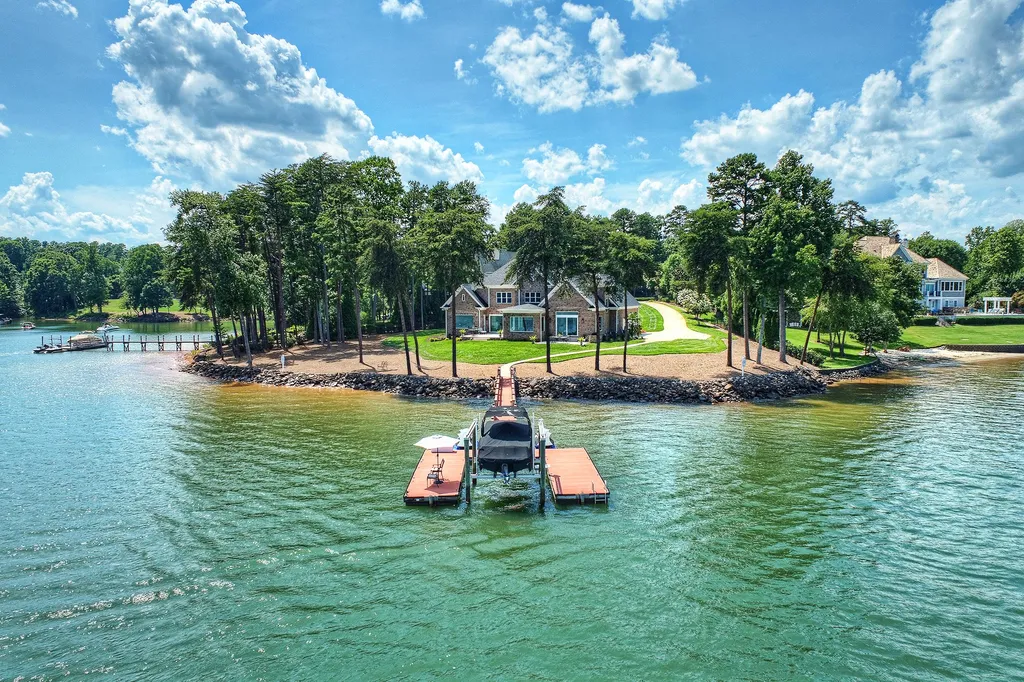 211 Quaker Road Home in Mooresville, North Carolina. Experience the ultimate waterfront living on Lake Norman with this beautifully renovated home situated on a 1.25-acre cul-de-sac lot boasting 365 ft of shoreline. Enjoy breathtaking lake views from almost every room, a stunning kitchen with Wolf & SubZero appliances, private pier with boat lift and Jet Ski docks, an elevator, and so much more. 