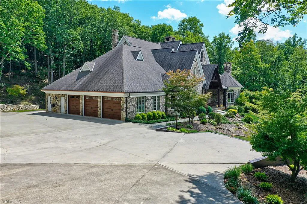 5712 Summit Road Home in Purlear, North Carolina. Explore this exceptional 128+ acre mountain retreat with a gated entrance, a timber-frame home boasting 5 bedrooms and 5 bathrooms. Enjoy the beauty of two spring-fed creeks that encircle the fieldstone exterior of the home.