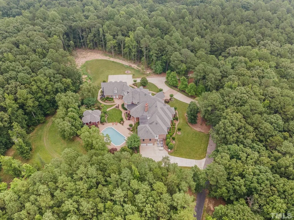 7728 Grace Cove Lane Home in Wake Forest, North Carolina. Discover this sprawling 31-acre estate featuring an exquisite all-brick home with custom features throughout. From reclaimed hardwoods to radiant heat flooring, this property exudes luxury. 