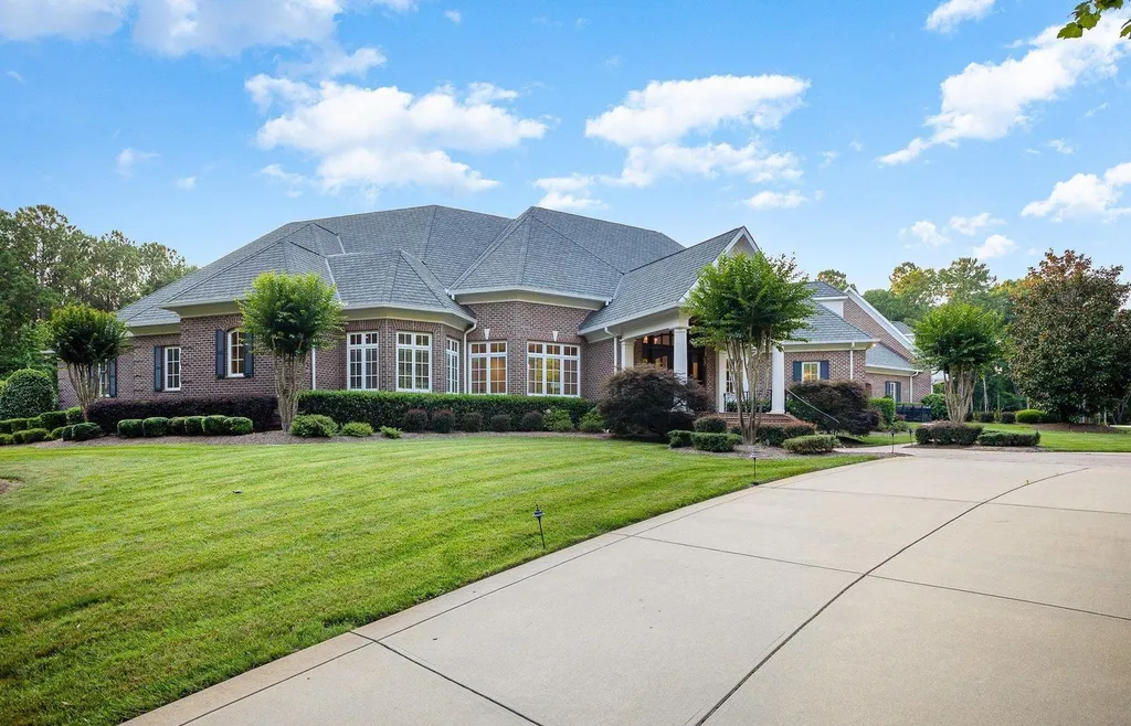 7728 Grace Cove Lane Home in Wake Forest, North Carolina. Discover this sprawling 31-acre estate featuring an exquisite all-brick home with custom features throughout. From reclaimed hardwoods to radiant heat flooring, this property exudes luxury. 