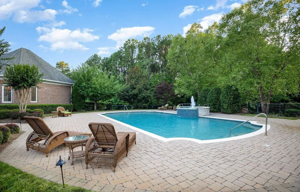 7728 Grace Cove Lane Home in Wake Forest, North Carolina. Discover this sprawling 31-acre estate featuring an exquisite all-brick home with custom features throughout. From reclaimed hardwoods to radiant heat flooring, this property exudes luxury. 