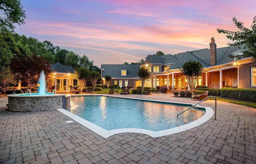 7728 Grace Cove Lane Home in Wake Forest, North Carolina. Discover this sprawling 31-acre estate featuring an exquisite all-brick home with custom features throughout. From reclaimed hardwoods to radiant heat flooring, this property exudes luxury. 
