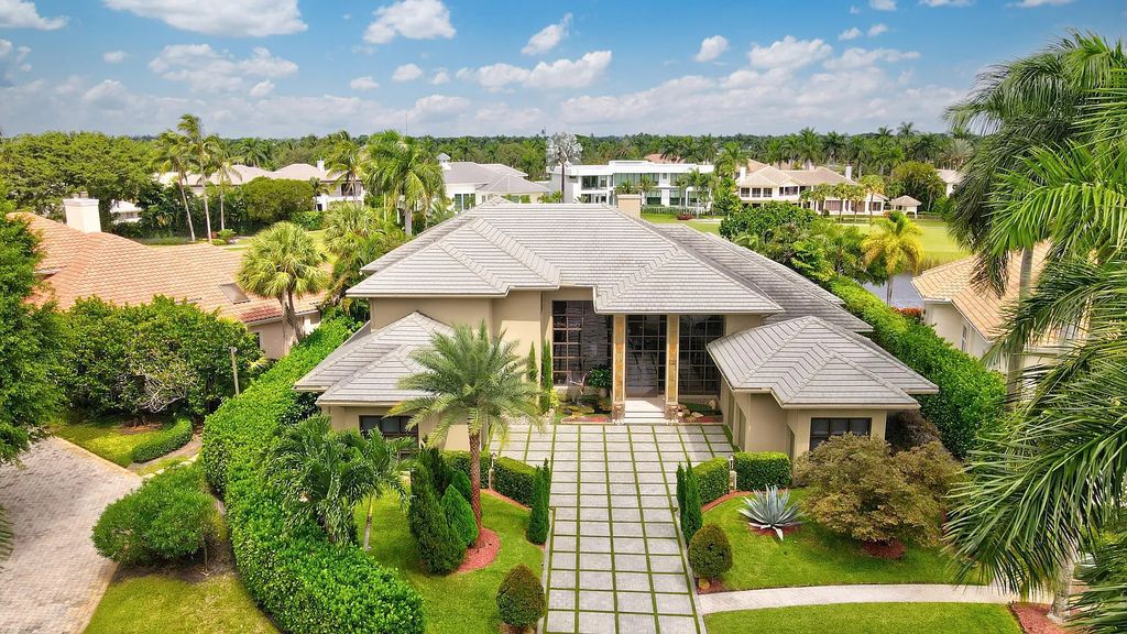 Welcome to 17999 Lake Estates Dr, Boca Raton, Florida, a Frank Lloyd Wright-inspired masterpiece that seamlessly marries modern luxury with natural beauty and advanced technology. This extraordinary estate greets you with dramatic two-story architecture and a 23-foot glass wall offering stunning views of the infinity pool, the sprawling lake, and the golf course.