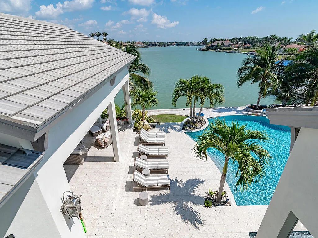 Discover your dream home at 1340 Caxambas Ct, Marco Island, Florida! This 5-bed, 5-bath luxury residence with a theater room boasts 5,007 sq ft of impeccable craftsmanship, situated on 0.59 acres with 248 ft of water frontage and a newer seawall, ensuring endless views and quick access to Caxambas Pass.