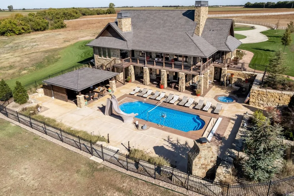 1051 North Blackstone Road Home in Milton, Kansas. Explore this breathtaking estate with cutting-edge technology and unmatched luxury nestled on 90 acres of pure prairie. With a net-zero energy design and fully furnished with farm equipment, this home offers ultimate sustainability.