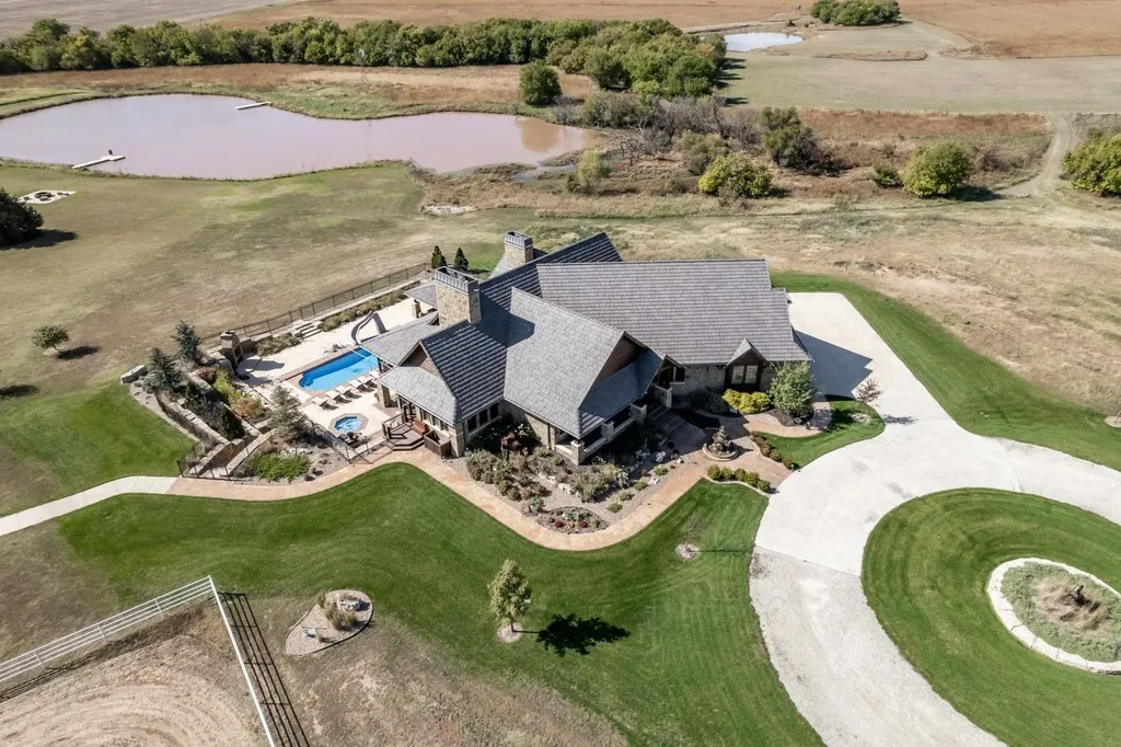 1051 North Blackstone Road Home in Milton, Kansas. Explore this breathtaking estate with cutting-edge technology and unmatched luxury nestled on 90 acres of pure prairie. With a net-zero energy design and fully furnished with farm equipment, this home offers ultimate sustainability.