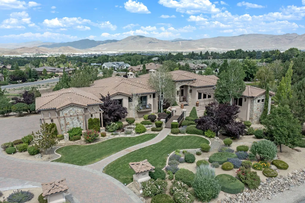 11180 Boulder Glen Way Home in Reno, Nevada. Discover this stunning luxury home in a secluded gated community offering panoramic views of Reno's cityscape and the Sierra Nevada mountains. This exquisite residence boasts a grand foyer, open-concept design, gourmet kitchen, master suite with a tranquil balcony, and en-suite bathrooms in every bedroom. 