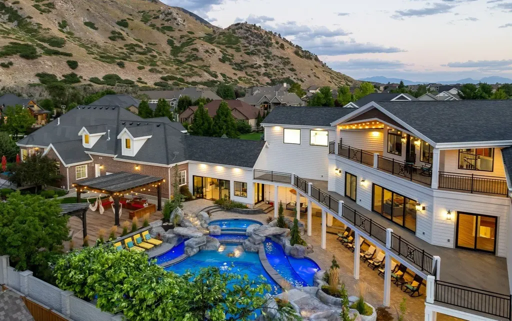 1263 East Chapman Court Home in Alpine, Utah. Step into the lap of luxury in this expansive 13,000 sq ft home in Alpine, Utah. With 8 oversized bedrooms, 6 bathrooms, a 13-car garage, and an outdoor entertainment paradise featuring a pool, spa, and lush landscaping, this property is perfect for hosting and living in grand style.