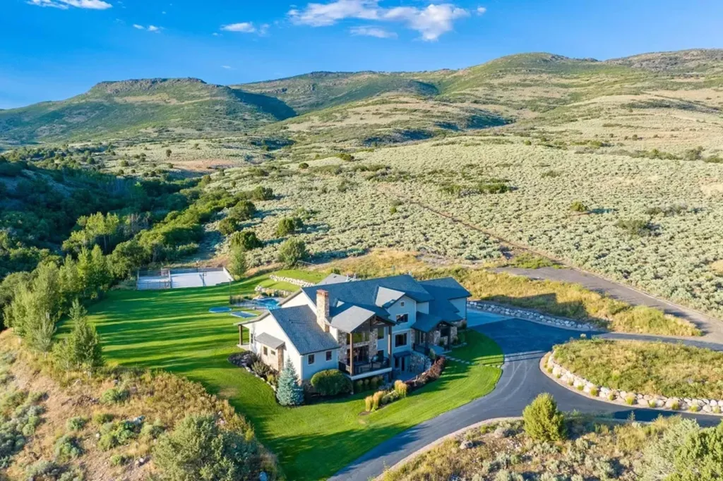 4115 Greener Hills Drive Home in Heber, Utah. Discover a 7.55-acre gated estate in Greener Hills. This luxury property features remarkable entertainment amenities, from exposed wood beams to a gourmet kitchen with Wolf appliances, an outdoor kitchen, pool, and firepit. The main level master offers radiant heat flooring, and the estate includes a playhouse, home theater, and more.
