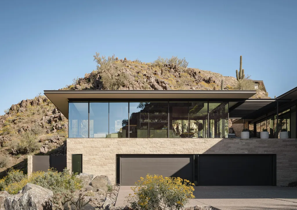 4301 E Upper Ridge Way Home in Paradise Valley, Arizona. Perched between two mountain peaks, the Upper Ridge Residence is an 8,000+ sf modern marvel designed by The Construction Zone. Featuring panoramic Valley of the Sun views, this steel and glass pavilion offers the highest level of craftsmanship.
