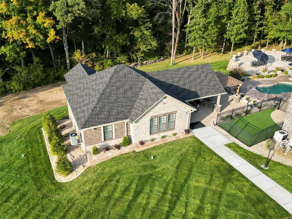 965 Stonecastle Drive Home in O'Fallon, Missouri. Discover the epitome of luxury living in this custom-built estate in Stonecastle subdivision, St. Paul. Boasting 5 bedrooms, 7 bathrooms, two kitchens, a home theater, in-ground hot tub, a 1400 sqft guest house, a 2000 sqft gym, and a 5-car oversized garage with a separate suite, this property offers unparalleled amenities for an elevated lifestyle.