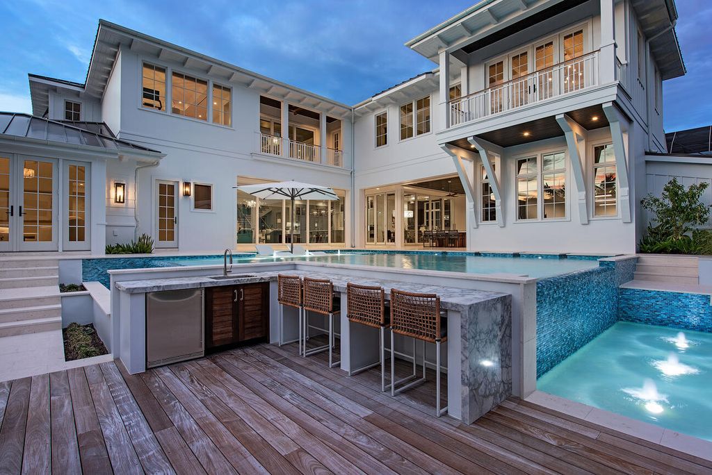 Discover the epitome of luxury living in Naples, Florida at this exquisite 5-bedroom, 7-bath cottage-style home located just moments from the Gulf. Designed by renowned developer VIV Homes in 2022, the property seamlessly blends classic charm with modern sophistication, boasting Italian-made custom closets, a chef's kitchen with premium appliances, and a state-of-the-art security system.