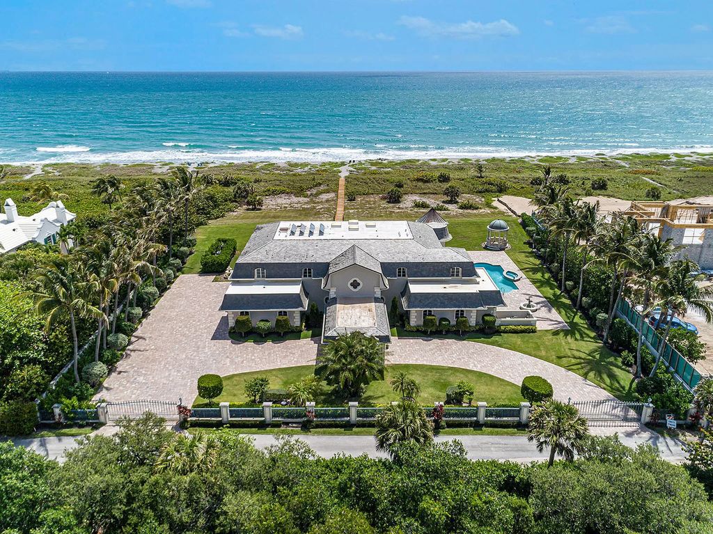 Indulge in the epitome of coastal luxury at 477 S Beach Rd, Hobe Sound, FL, nestled on Jupiter Island's southern tip. This stunning estate offers 242 feet of direct ocean frontage on 2.62 acres, providing unparalleled privacy and breathtaking views.