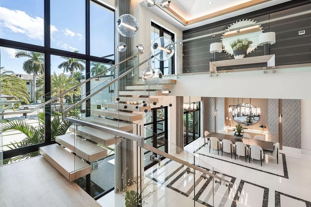 Indulge in the epitome of waterfront luxury at this 10,784-square-foot estate in Royal Palm Yacht & Country Club. Crafted by Wietsma Lippolis Construction, this masterpiece boasts six bedroom suites, expansive living areas curated by Artisan Interiors, and cutting-edge Crestron home technology.
