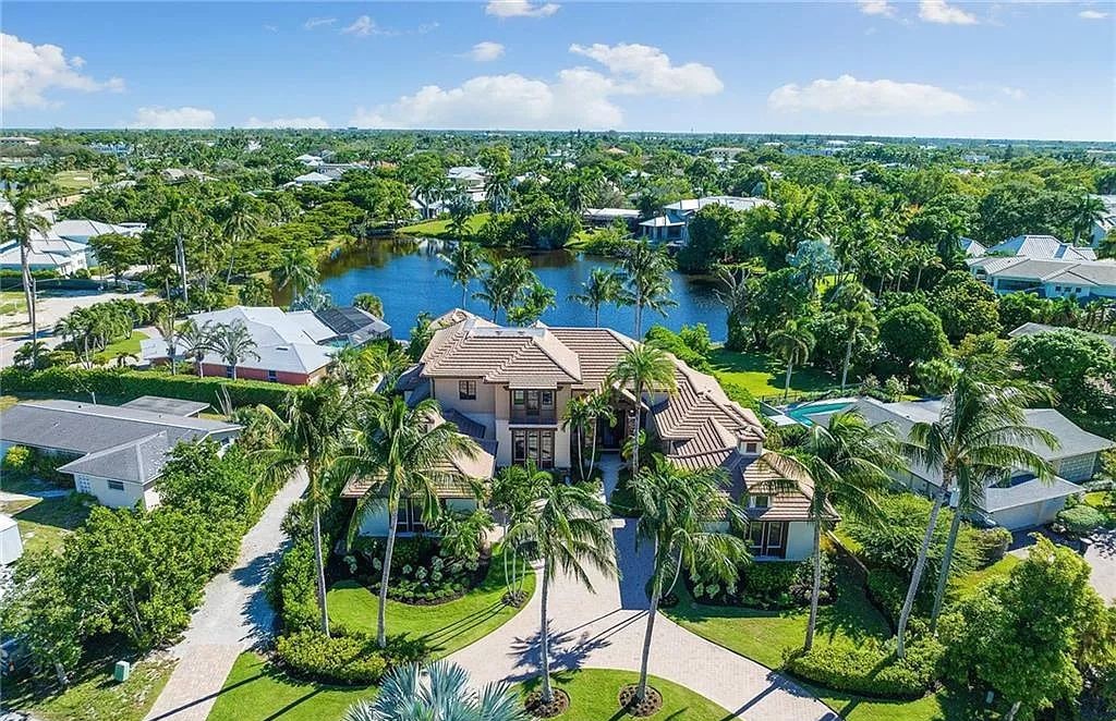 Discover the epitome of luxury living in the heart of Naples at 655 Bougainvillea Rd. This exquisite 7,660-square-foot lakefront estate, crafted by renowned architect John Cooney, boasts a seamless blend of warm tones and minimalist design.