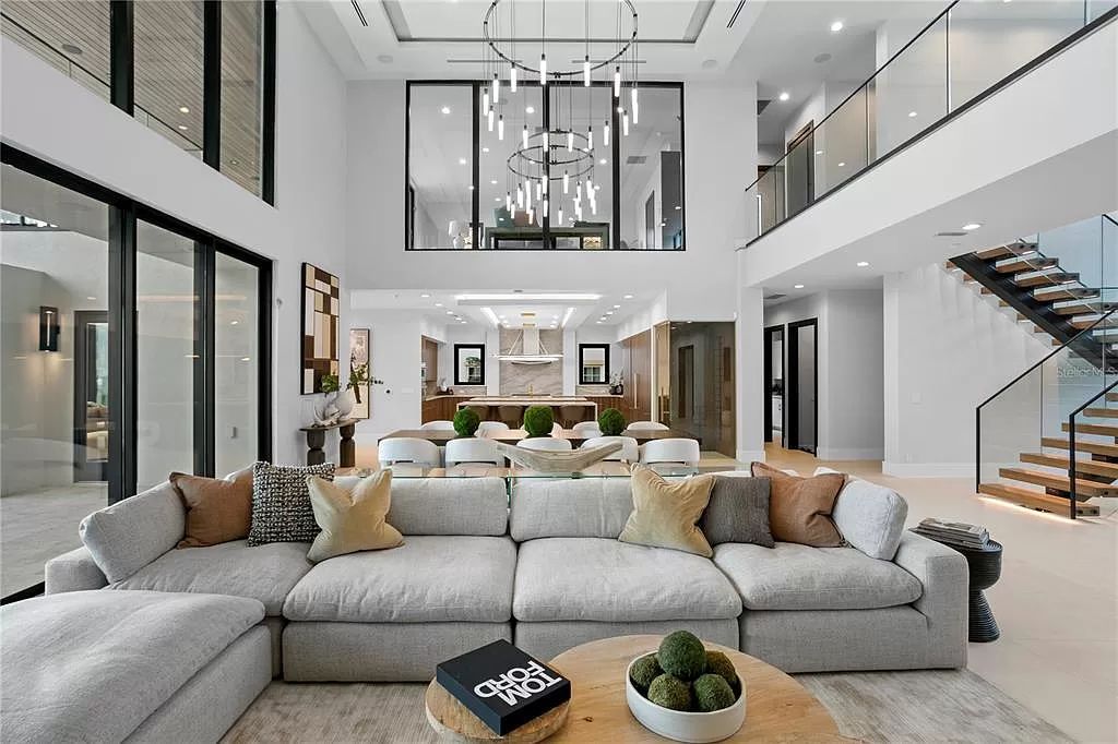 This 7,087-square-foot modern marvel at 1721 Brightwaters Blvd NE in St. Petersburg's Snell Isle boasts 100’ of Tampa Bay waterfront, offering breathtaking views. A grand entrance leads to a great room with soaring ceilings and water vistas, complemented by a chef’s kitchen and outdoor spaces ideal for entertaining.