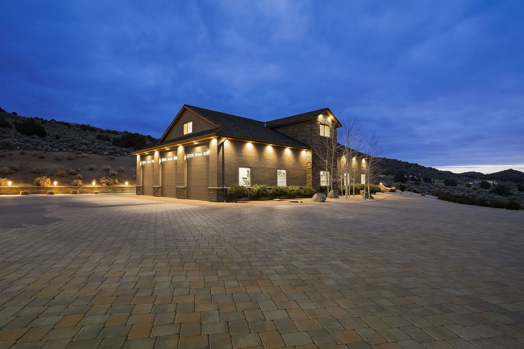 5269 Axe Handle Road Home in Reno, Nevada. Discover unparalleled luxury and privacy in this exclusive estate perched atop an elevated knoll on 80 fenced acres. Featuring a separate 15-car garage, a stunning main residence seamlessly blending designer finishes with panoramic mountain and valley views.