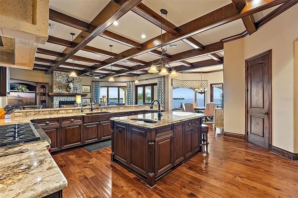 This 2014 waterfront marvel by Campagna Homes offers the pinnacle of luxury living across two lots with direct Tampa Bay access. Boasting 5 bedrooms, 6.5 baths, and versatile spaces including an office, gym, and game room with a wet bar, this 7,841-square-foot masterpiece features a gourmet kitchen, Swarovski crystal-adorned dining room, and a gas fireplace-lit living room.
