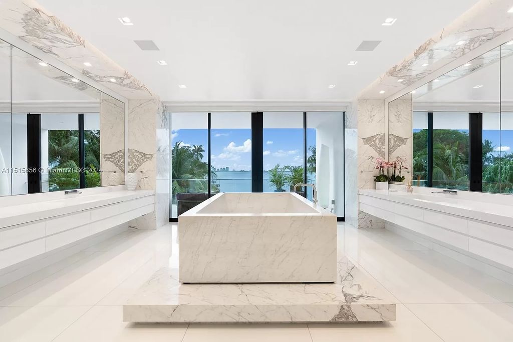 Welcome to 5004 N Bay Rd, a 2016 masterpiece by renowned designer Jennifer Post, blending modern architecture with timeless elegance. This 8-bed, 9-bath waterfront haven on prestigious North Bay Road boasts a stunning atrium courtyard, seamless living spaces, and a gourmet kitchen.