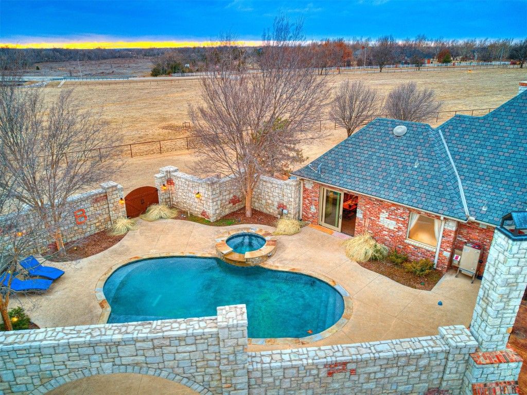 19700 N Macarthur Boulevard Home in Edmond, Oklahoma. Discover the epitome of luxury living on this breathtaking 80-acre Deer Creek estate, complete with equestrian facilities, a serene 3-acre pond, and a remodeled house boasting full guest quarters. 