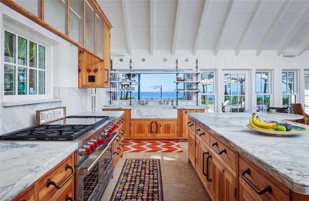 Nestled on nearly half an acre of prime beachfront land in Olde Naples, this exceptional home seamlessly blends coastal elegance with timeless craftsmanship.