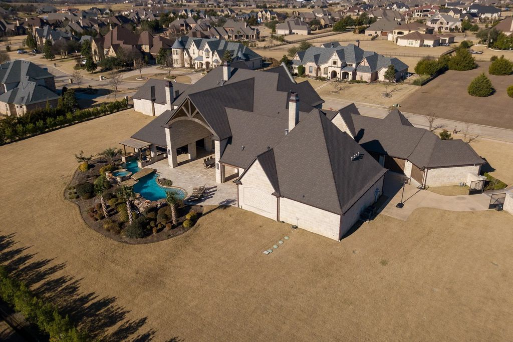 1252 Wales Drive Home in Rockwall, Texas. Step into luxury living at its finest with this illustrious estate set on over two private acres. Enjoy resort-style amenities including a pool with swim-up bar, fire features, waterfalls, and a covered patio with motorized screens.