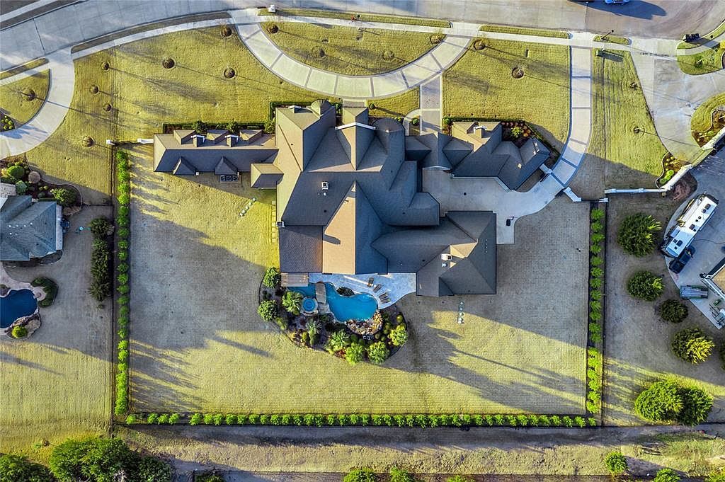 1252 Wales Drive Home in Rockwall, Texas. Step into luxury living at its finest with this illustrious estate set on over two private acres. Enjoy resort-style amenities including a pool with swim-up bar, fire features, waterfalls, and a covered patio with motorized screens.