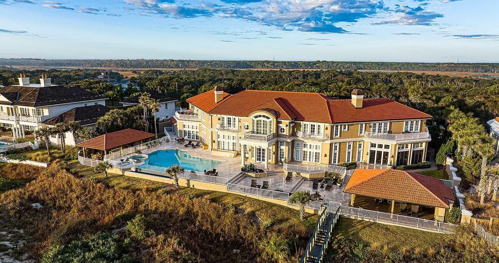 With 30' elevations, this opulent residence offers resort-style amenities for luxurious entertaining, including a gourmet kitchen, dine-in wine cellar, grand dining room, and a first-floor owner's wing with office, library, and outdoor living space.