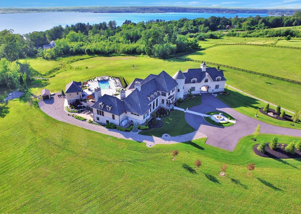 65 Brown Road Home in Stillwater, New York. Experience unparalleled luxury in this exquisite French Country Chateau nestled on 15 acres with stunning views of Saratoga Lake. Boasting 7,237 SF, this custom mansion features 5 bedroom suites, 7.5 baths, and a separate pool house with kitchenette, bathroom, and fireplace. 