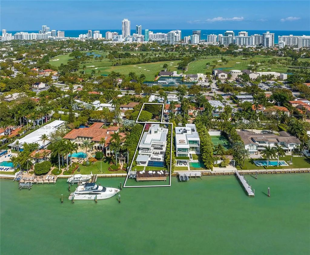 The stunning waterfront mansion at 5718 N Bay Rd offers breathtaking views of the Miami skyline, complemented by a meticulously remodeled 4-bedroom residence at 5725 N Bay Rd.