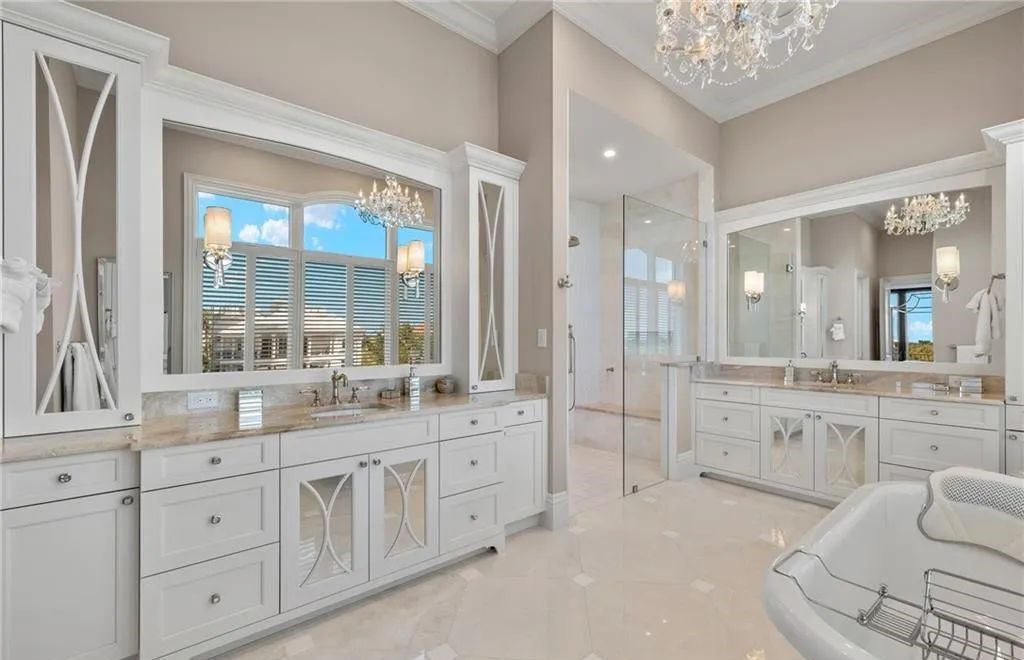 Crafted by Potter Homes in 2019, this exquisite residence boasts panoramic views of the bay and Gulf, complemented by deeded beach access to Barefoot Beach.