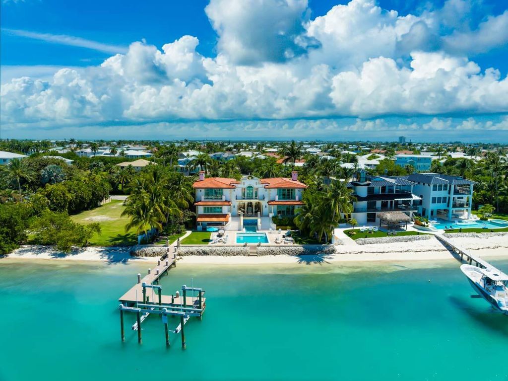 Indulge in the epitome of luxury living at this stunning oceanfront estate in Key Colony Beach. Nestled on an oversized lot, this home offers unrivaled amenities including an in-ground saltwater pool, private sandy beach, firepit, and a sprawling dock with a boat lift.