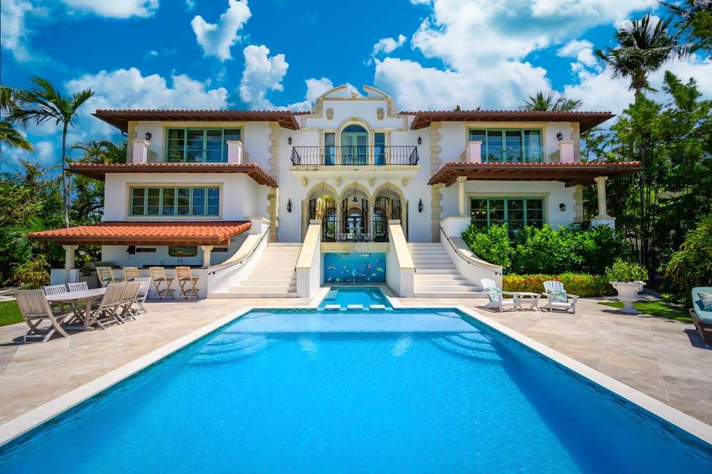 Indulge in the epitome of luxury living at this stunning oceanfront estate in Key Colony Beach. Nestled on an oversized lot, this home offers unrivaled amenities including an in-ground saltwater pool, private sandy beach, firepit, and a sprawling dock with a boat lift.