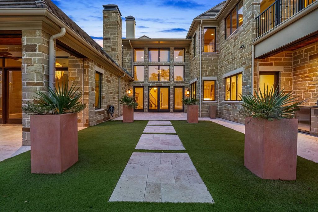 1702 Carlyle Court Home in Westlake, Texas. Discover the allure of this stunning Calais Custom home situated on a rare 1.5-acre lot in Westlake. Featuring grand foyer, gourmet kitchen, glass-encased wine cellar, game room with wet bar, and luxurious master suite with outdoor access.