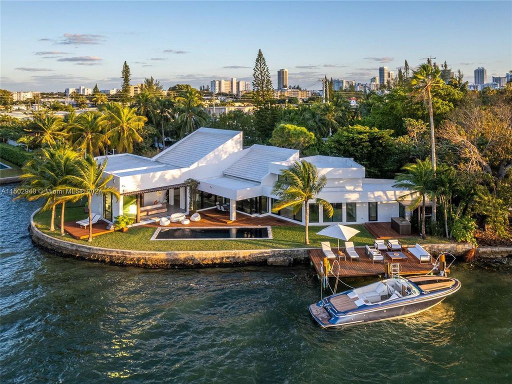 Discover unparalleled luxury in this modern masterpiece on guard-gated Biscayne Point Island. This exquisitely renovated home offers wide bay sunset views from a private peninsula with 360 feet of water frontage.