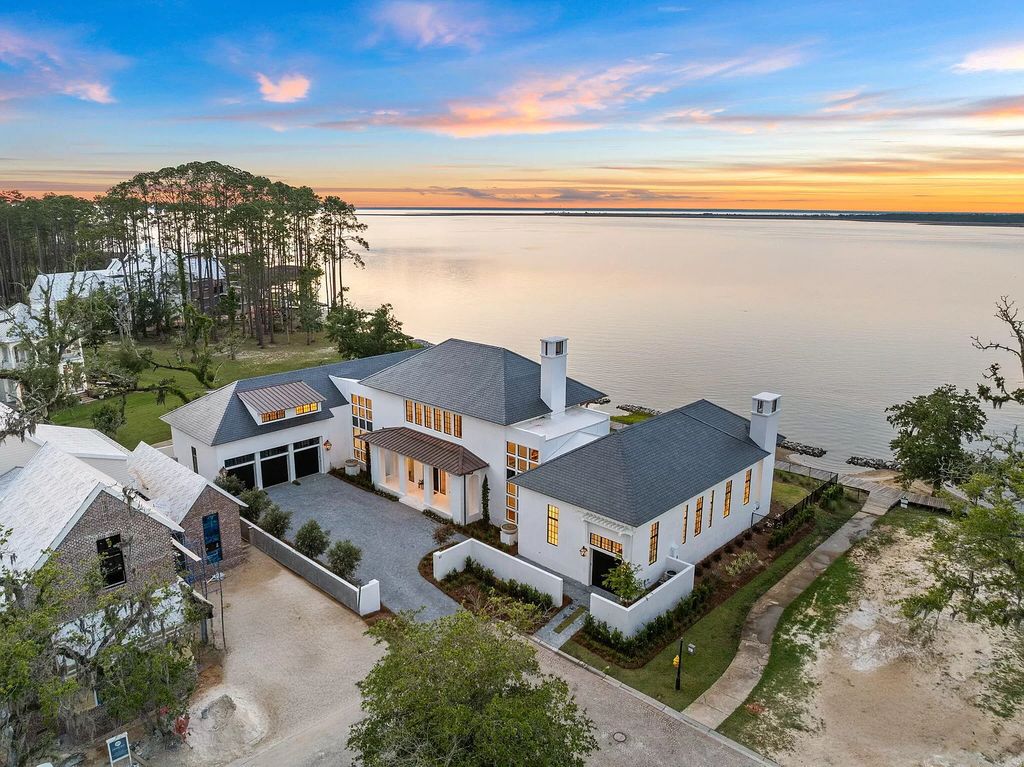 Nestled on a double homesite with 150'+ of Choctawhatchee Bay frontage in the prestigious gated enclave of Churchill Oaks, 51 Junop Court is a stunning legacy residence designed by Matt Savois and built by Grand Bay Construction.
