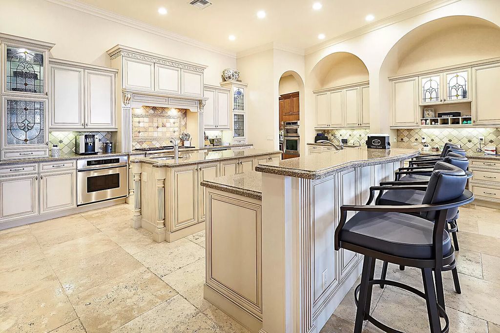 This dream home features a home office, theater, chef's kitchen with high-end appliances, dual-zone wine refrigerators, and lavish architectural details.