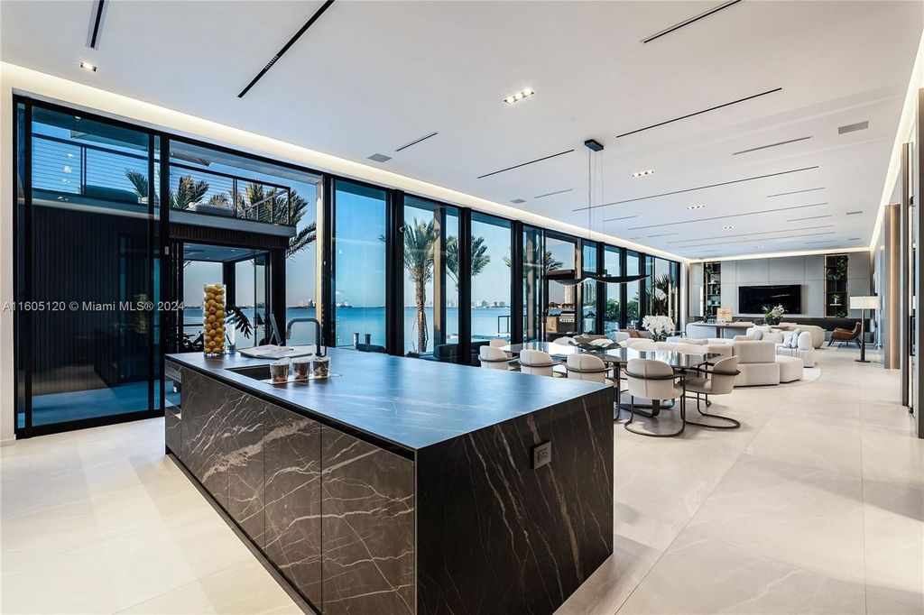 Designed by Portuondo Perotti, this 12,633 SF mansion at 11420 N Bayshore Dr, North Miami, epitomizes luxury with 102 feet of waterfront offering stunning bay and downtown Miami views.
