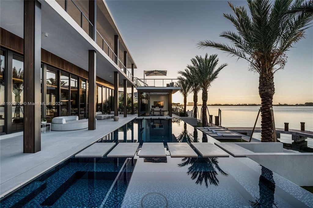 Designed by Portuondo Perotti, this 12,633 SF mansion at 11420 N Bayshore Dr, North Miami, epitomizes luxury with 102 feet of waterfront offering stunning bay and downtown Miami views.