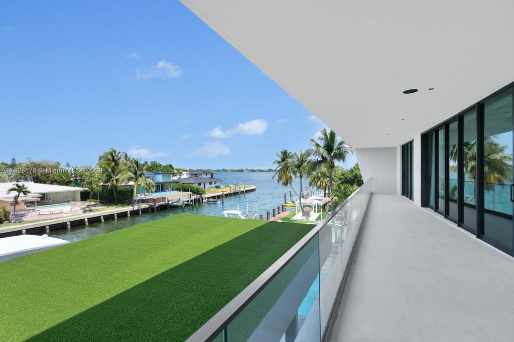 Discover an extraordinary waterfront compound in gated San Souci Estates, featuring a brand new ultra-modern home and a sophisticated guest house on a double lot.